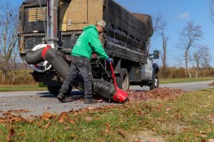 Worker using leaf cleanup machine
