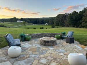 Natural stone patio with firepit overlooking the back yard