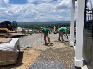 People raking rocks for surface for patio